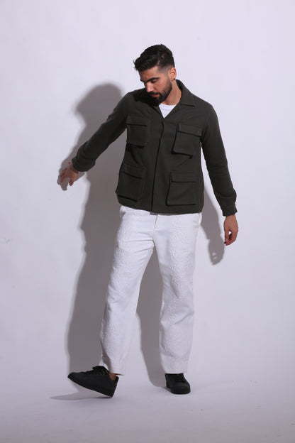 Person wearing a black jacket and white pants on a white background