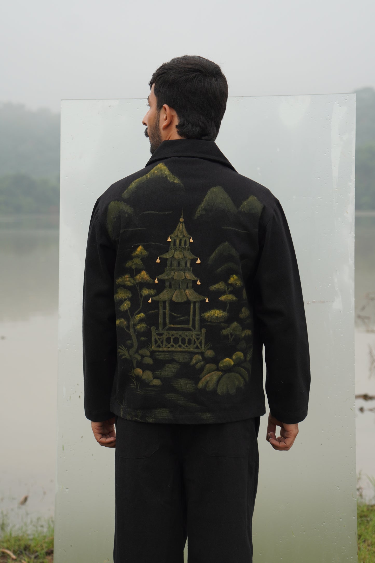 A black Beck Unisex Hand-Painted Jacket seen from the front. The alt texts say, "Unisex 
black cotton denim twill jacket with hand-painted artwork" and "Beck hand-painted 
jacket in black, featuring unique artwork." 